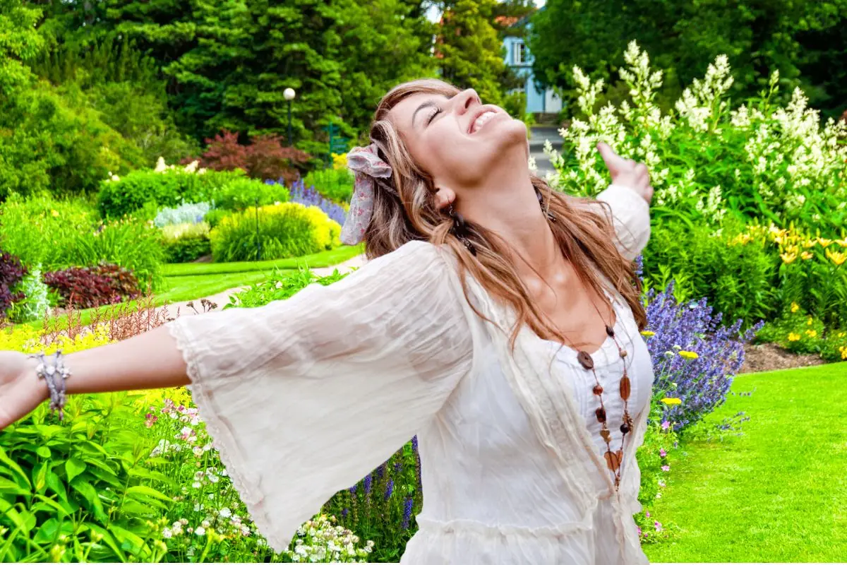 woman with opened arms in botanical garden