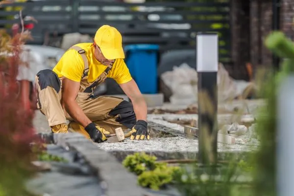 Professional Landscaping Worker Building Garden Brick Path